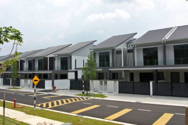 SELANGOR, MALAYSIA - JUNE 18, 2022: New double-story terrace house under construction in Malaysia. This house has a wide front porch and is fenced. Has basic facilities.