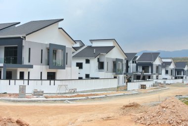 SELANGOR, MALAYSIA - JUNE 18, 2022: New double-story terrace house under construction in Malaysia. This house has a wide front porch and is fenced. Has basic facilities.