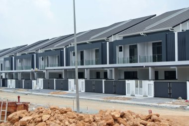 SELANGOR, MALAYSIA - JUNE 18, 2022: New double-story terrace house under construction in Malaysia. This house has a wide front porch and is fenced. Has basic facilities.