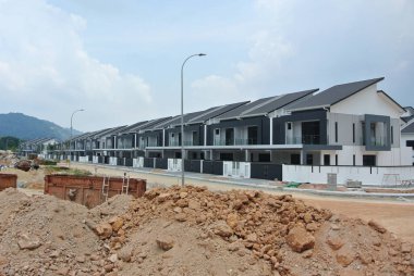 SELANGOR, MALAYSIA - JUNE 18, 2022: New double-story terrace house under construction in Malaysia. This house has a wide front porch and is fenced. Has basic facilities.