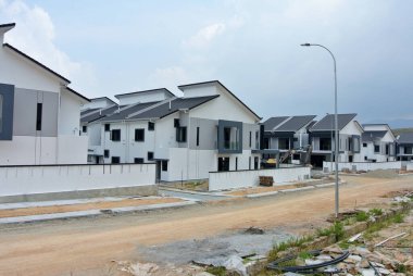 SELANGOR, MALAYSIA - JUNE 18, 2022: New double-story terrace house under construction in Malaysia. This house has a wide front porch and is fenced. Has basic facilities.