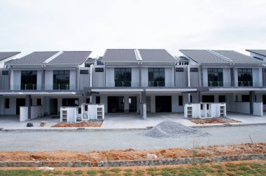 SELANGOR, MALAYSIA - JUNE 18, 2022: New double-story terrace house under construction in Malaysia. This house has a wide front porch and is fenced. Has basic facilities.