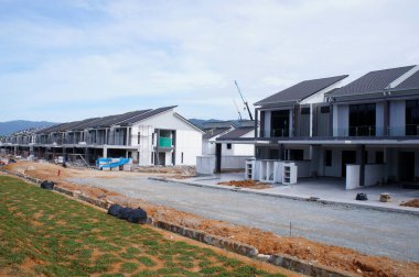 SELANGOR, MALAYSIA - JUNE 18, 2022: New double-story terrace house under construction in Malaysia. This house has a wide front porch and is fenced. Has basic facilities.