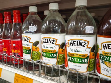 SEREMBAN, MALAYSIA -MAY 5, 2022: Various brands of cooking vinegar in commercial labeled bottles and displayed on shelves for sale. Has a price tag. Neatly arranged to attract customers' attention.