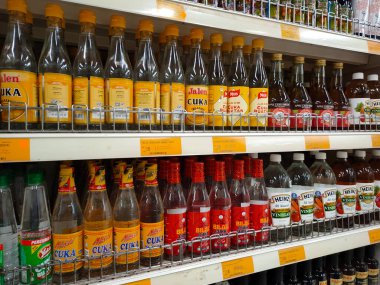 SEREMBAN, MALAYSIA -MAY 5, 2022: Various brands of cooking vinegar in commercial labeled bottles and displayed on shelves for sale. Has a price tag. Neatly arranged to attract customers' attention.