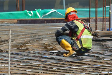 MALACCA, MALAYSIA -JULY 23, 2016: Construction workers wearing safety harness belt at other safety gear during working at the construction site area.  