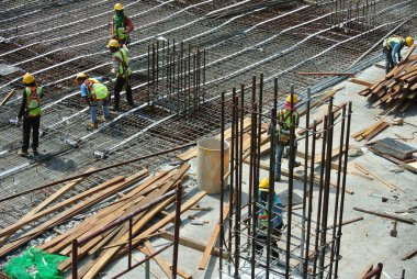 Malacca, Malaysia-27 Haziran 2016: Malacca, Malaysia inşaat sahasında çelik takviye çubuğu imalatı inşaat işçileri. Birlikte küçük tel kullanarak bağları güçlendirme bardı.  