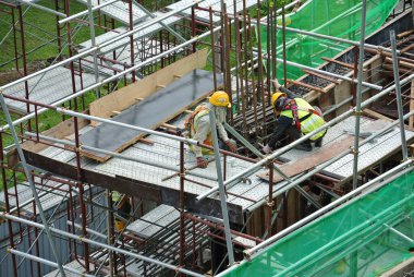 Malacca, Malaysia-27 Haziran 2016: Malacca, Malaysia inşaat sahasında çelik takviye çubuğu imalatı inşaat işçileri. Birlikte küçük tel kullanarak bağları güçlendirme bardı.  