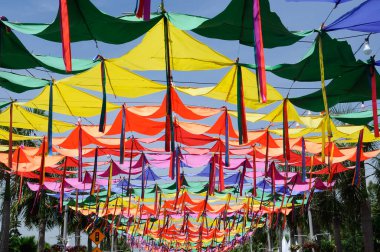 PUTRAJAYA, MALAYSIA -MAY 30, 2016: Sidewalk in Floria Putrajaya in the shade by a sheet of colorful cloth tied together.