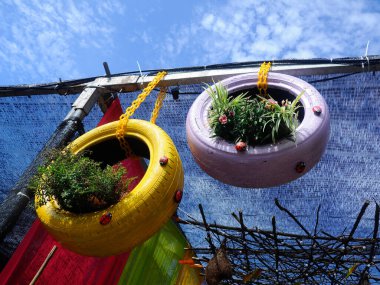 PUTRAJAYA, MALAYSIA -MAY 30, 2016: Flowers planted in used tires and hanging as decoration.