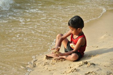 PORT DICKSON, MALAYSIA - MAY 8, 2016: Kids having fun playing sand on the beach.