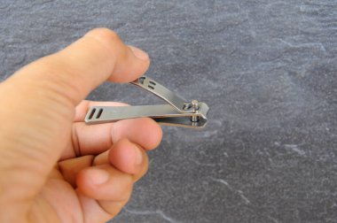 Hand holding and using nail clippers