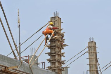 MALACCA, MALAYSIA -18 Haziran 2016: Malacca, Malezya 'daki inşaat alanında sütun kerestesi üreten inşaat işçileri. 
