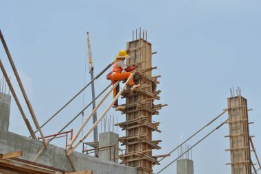 MALACCA, MALAYSIA -18 Haziran 2016: Malacca, Malezya 'daki inşaat alanında sütun kerestesi üreten inşaat işçileri. 
