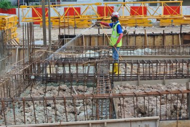 JOHOR, MALAYSIA - 29 Mart 2016: İnşaat işçileri termit karşıtı kimyasal tedaviyi inşaat alanındaki toprağa püskürtüyorlar. 