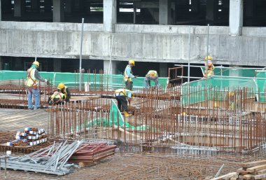 Malacca, Malaysia-27 Haziran 2016: Malacca, Malaysia inşaat sahasında çelik takviye çubuğu imalatı inşaat işçileri. Birlikte küçük tel kullanarak bağları güçlendirme bardı.  