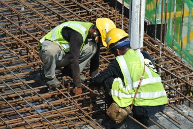 Malacca, Malaysia-27 Haziran 2016: Malacca, Malaysia inşaat sahasında çelik takviye çubuğu imalatı inşaat işçileri. Birlikte küçük tel kullanarak bağları güçlendirme bardı.  