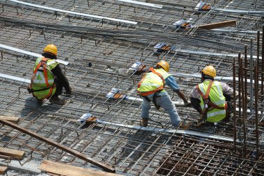 Malacca, Malaysia-27 Haziran 2016: Malacca, Malaysia inşaat sahasında çelik takviye çubuğu imalatı inşaat işçileri. Birlikte küçük tel kullanarak bağları güçlendirme bardı.  