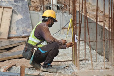 Malacca, Malaysia-27 Haziran 2016: Malacca, Malaysia inşaat sahasında çelik takviye çubuğu imalatı inşaat işçileri. Birlikte küçük tel kullanarak bağları güçlendirme bardı.  