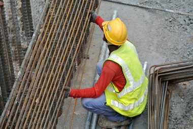 Malacca, Malaysia-27 Haziran 2016: Malacca, Malaysia inşaat sahasında çelik takviye çubuğu imalatı inşaat işçileri. Birlikte küçük tel kullanarak bağları güçlendirme bardı.  
