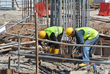 Malacca, Malaysia-27 Haziran 2016: Malacca, Malaysia inşaat sahasında çelik takviye çubuğu imalatı inşaat işçileri. Birlikte küçük tel kullanarak bağları güçlendirme bardı.  