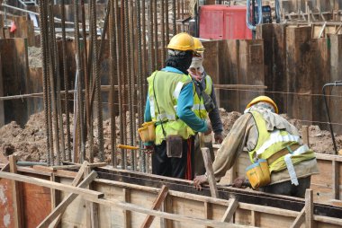 MALACCA, MALAYSIA -MAY 25, 2016: Construction workers fabricating timber form work at the construction site in Malacca, Malaysia. The form work was mainly made from timber and plywood. 