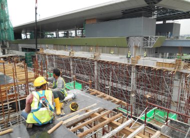 MALACCA, MALAYSIA -MAY 25, 2016: Construction workers fabricating timber form work at the construction site in Malacca, Malaysia. The form work was mainly made from timber and plywood. 