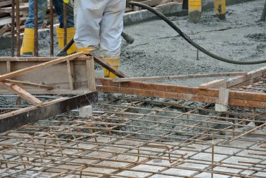 SELANGOR, MALAYSIA -APRIL 16, 2016: Construction workers using a concrete vibrator at the construction site to compact concrete slurry that pour in the form work. 
