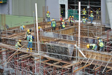 SELANGOR, MALAYSIA -MAY 13, 2016: Construction workers working at the construction site at Serdang, Malaysia during daytime. They are wearing proper safety gear so ensure they are safe working.  