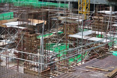 KLANG, MALAYSIA -MAY 13, 2016: Construction workers working at the construction site at Serdang, Malaysia during daytime. They are wearing proper safety gear so ensure they are safe working.  