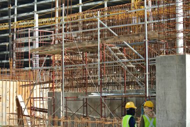 KLANG, MALAYSIA -MAY 13, 2016: Construction workers working at the construction site at Serdang, Malaysia during daytime. They are wearing proper safety gear so ensure they are safe working.  