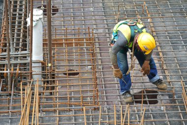 MALACCA, MALAYSIA -27 Mayıs 2016: Malezya 'daki inşaat alanında çelik takviye barı üreten inşaat işçileri. Destek çubuğu ince kabloyla birbirine bağlıydı..  