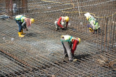 MALACCA, MALAYSIA -27 Mayıs 2016: Malezya 'daki inşaat alanında çelik takviye barı üreten inşaat işçileri. Destek çubuğu ince kabloyla birbirine bağlıydı..  