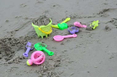 Kitchen ware toys made from plastic on beach. 