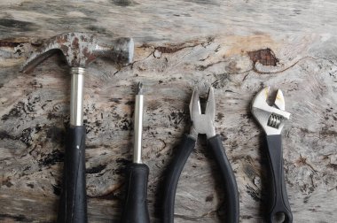 Carpentry hardware that has a black rubber coated handle. Isolated with wood grain backs.