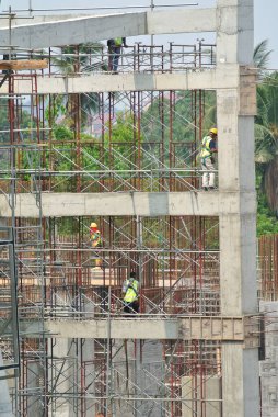 PERAK, MALAYSIA -APRIL 05, 2016: İnşaat işçileri emniyet kemeri takıyor ve şantiyeye yüksek seviyede yapı iskelesi kuruyor. 