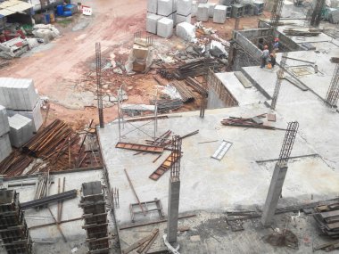 MELAKA, MALAYSIA - 5 Haziran 2022: İnşaat işçileri güvenliklerinden emin olmak için yükseklerde çalışır ve güvenlik teçhizatı giyerler. Gruplar halinde çalışır ve görevlerini yerine getirirler..