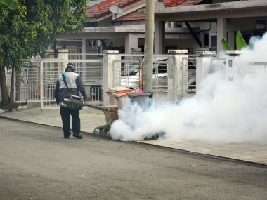 MELAKA, MALAYSIA - 1 Haziran 2022: Sivrisinek savar sisi özel bir makine kullanılarak gerçekleştiriliyor. Sprey işçileri zehrin kokusunu almamak için özel bir maske takmak zorundadırlar..