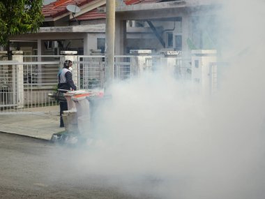 MELAKA, MALAYSIA - 1 Haziran 2022: Sivrisinek savar sisi özel bir makine kullanılarak gerçekleştiriliyor. Sprey işçileri zehrin kokusunu almamak için özel bir maske takmak zorundadırlar..