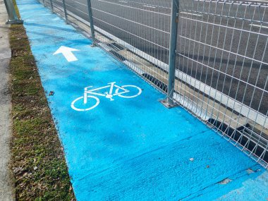 Yolun kenarında bisiklet sürmek için özel bir yol. Maviyle boyanmış, böylece daha net görülebiliyor. Genişliği eşit ve bisikletçiler için uygun..