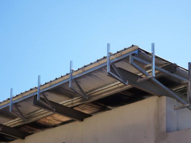 MELAKA, MALAYSIA - 16 Eylül 2022: Çatıdaki alüminyum kaplama çerçevesinin kurulumu devam ediyor. Metal güverte çatı sistemi ısıya dayanıklı silsalasyon katmanıyla donatılmıştır..