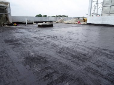 MELAKA, MALAYSIA - 1 Temmuz 2022: İnşaat işçileri tarafından beton levhanın üzerine uygulanan su geçirmez zar. Su geçirmez katman beton levhanın altından suyla geçmesini engellemek için.. 