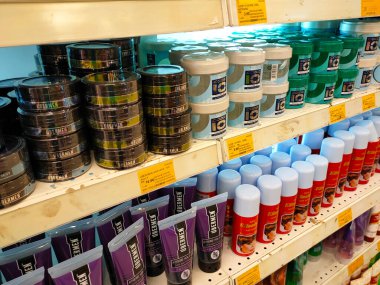 JOHOR, MALAYSIA - 4 Nisan 2022: Erkeklerin saç kremleri ve jelleri bir mağazada satışa sunuldu. Ticari paketler halinde paketlenmiş. Bir fiyat etiketi var ve marka ve tipe göre ayrılır.