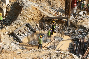 JOHOR, MALAYSIA - 5 Mart 2022: Çelik takviye çubuğu inşaat kapağı yapımında kullanılan malzemelerden biridir. İnşaat işçileri destek çubuğunu küçük çelik tellerle bağlıyorlar..