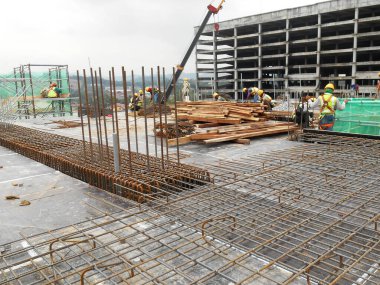 JOHOR, Malezya - 17 Haziran 2022 İnşaat alanı devam ediyor. İnşaat çalışmaları aşamalı olarak yürütülüyor. İnşaat işçileri sıkı güvenlik denetimi altında iş yapıyorlar..