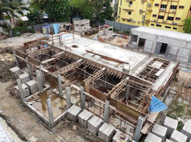 JOHOR, Malezya - 17 Haziran 2022 İnşaat alanı devam ediyor. İnşaat çalışmaları aşamalı olarak yürütülüyor. İnşaat işçileri sıkı güvenlik denetimi altında iş yapıyorlar..