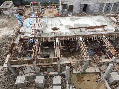 JOHOR, Malezya - 17 Haziran 2022 İnşaat alanı devam ediyor. İnşaat çalışmaları aşamalı olarak yürütülüyor. İnşaat işçileri sıkı güvenlik denetimi altında iş yapıyorlar..