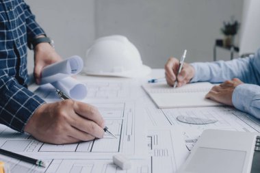 İnşaat mühendisi mühendisi. İş yerindeki mühendislik objeleri ile partnerler arka planda etkileşime giriyor. Mimari proje için mühendis toplantısı resmi.