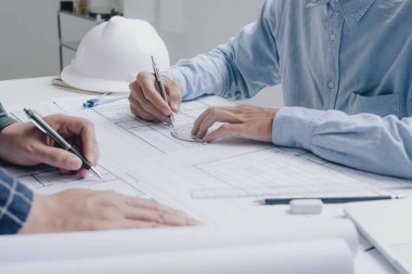 İnşaat mühendisi mühendisi. İş yerindeki mühendislik objeleri ile partnerler arka planda etkileşime giriyor. Mimari proje için mühendis toplantısı resmi.