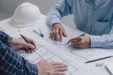 İnşaat mühendisi mühendisi. İş yerindeki mühendislik objeleri ile partnerler arka planda etkileşime giriyor. Mimari proje için mühendis toplantısı resmi.